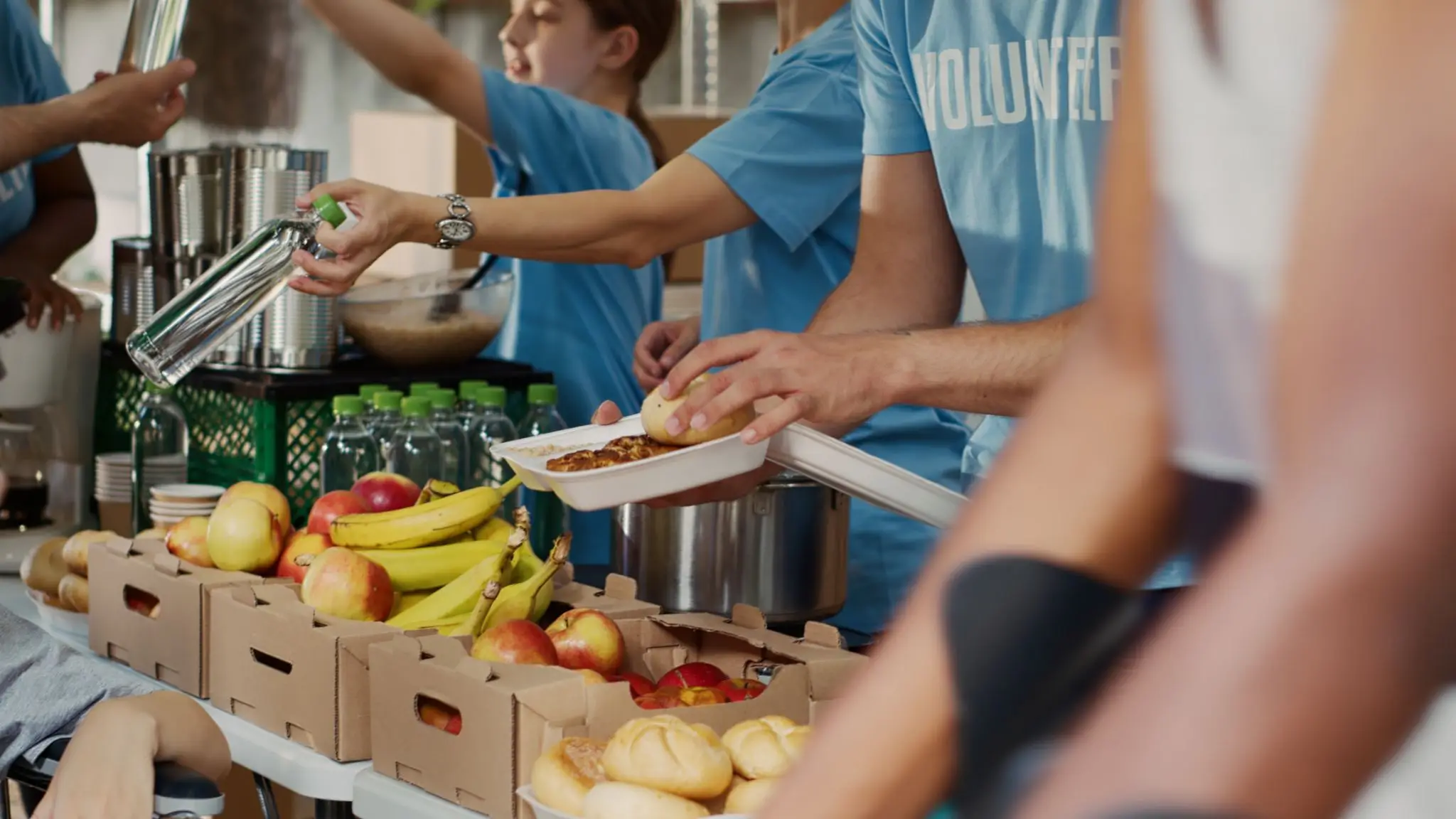 Volunteers serving meals and produce at food bank