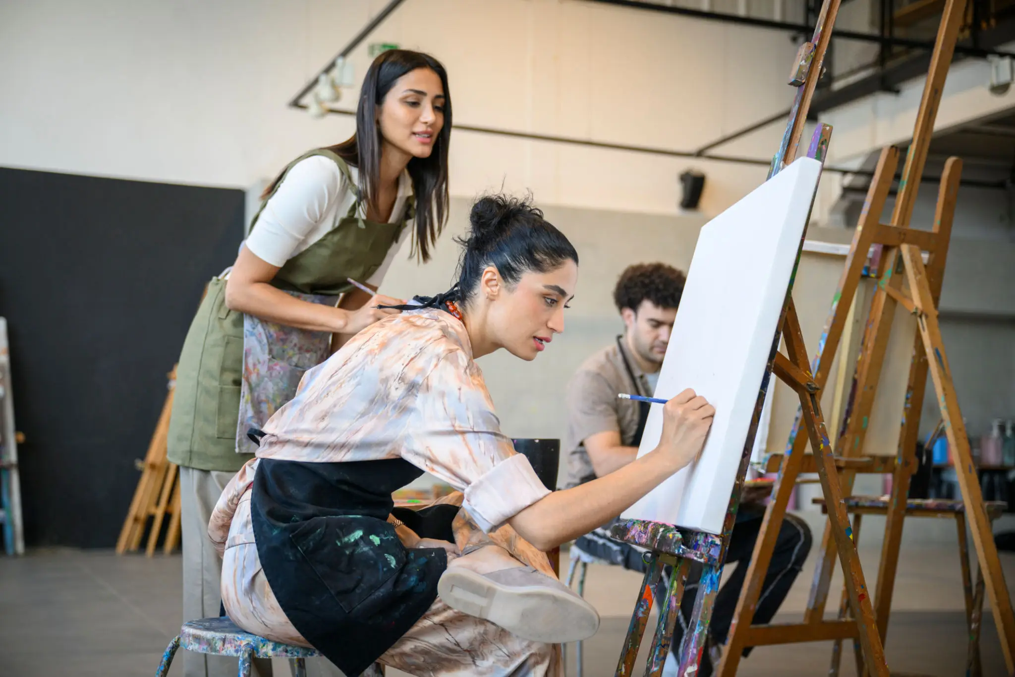 Artists painting on easels in studio